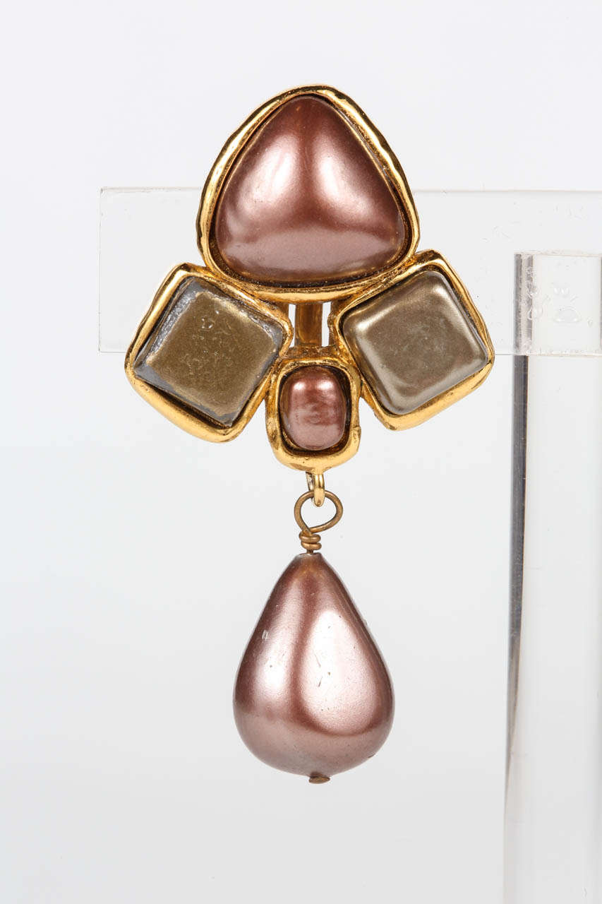 An elegant pair of drop ear clips by Chanel, featuring pearlized glass in taupe and olive. Marked on the back with a 