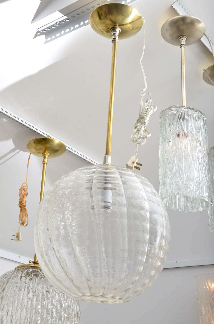 Textured glass open bottom globe pendant with brass rod and canopy wired up to 100 watts standard bulb