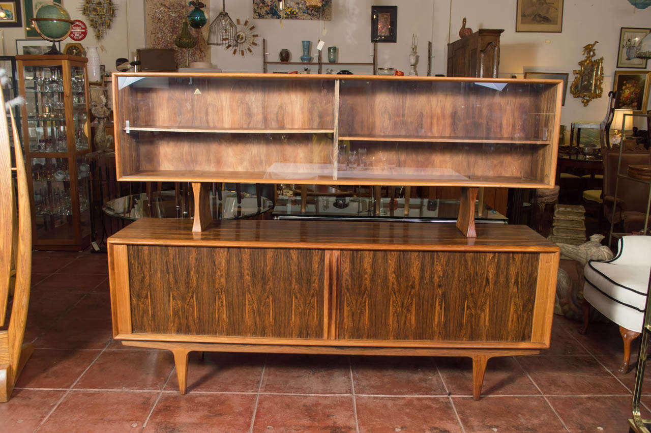 A stunning Danish modern Rosewood credenza and hutch, by Bernhard Pederson & Sons, Denmark. Tambour doors on the main unit, behind those doors are four drawers in the middle and three adjustable shelves. The hutch, has two sliding glass doors with