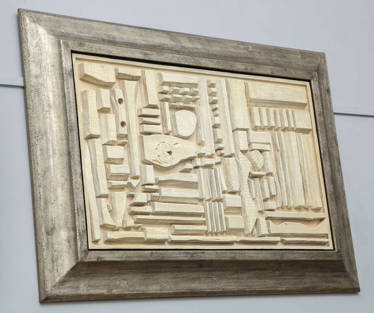 Anonymous oak relief, circa 1960 in the spirit of Louise Nevelson framed in a white gold gilded slope away frame, finished with a rough gesso with a black wash.