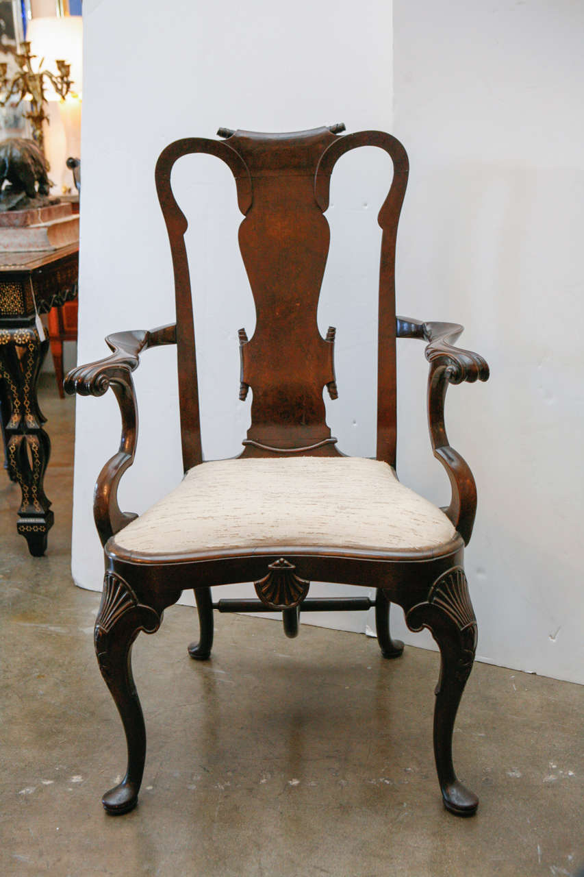 Twelve, hand-carved English dining chairs with unusual, scroll-form top rails, large, shell relief cartouches on the knees and apron, and Queen Anne legs.