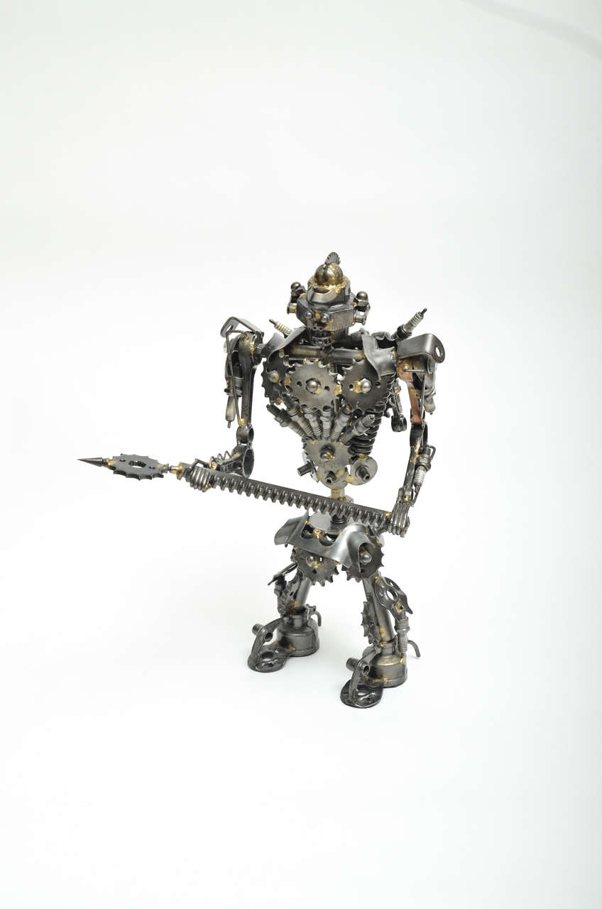 Unusual articulated robot warrior sculpture composed of miscellaneous welded scrap parts.