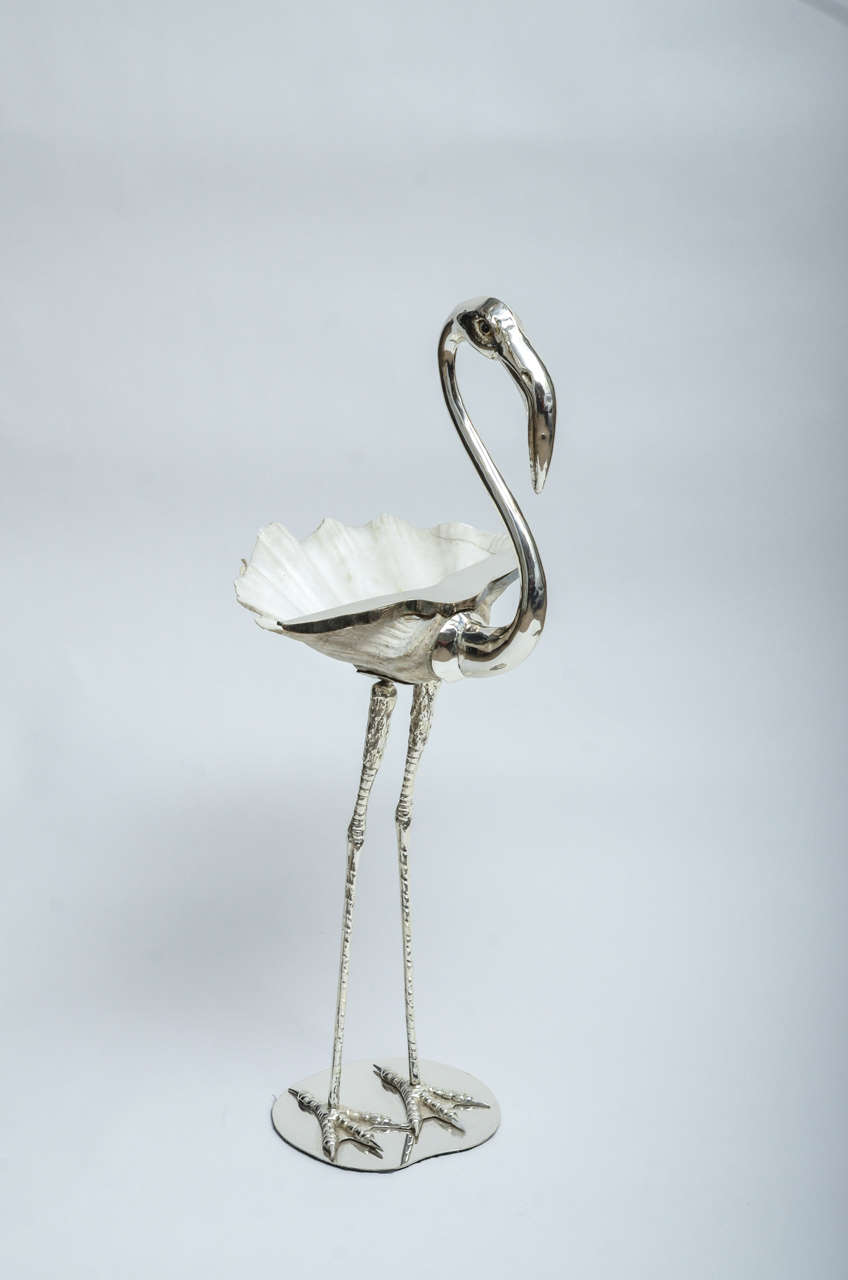 Silver plated flamingo sculpture featuring large shell.
Shell has repaired hairline crack and a chip.