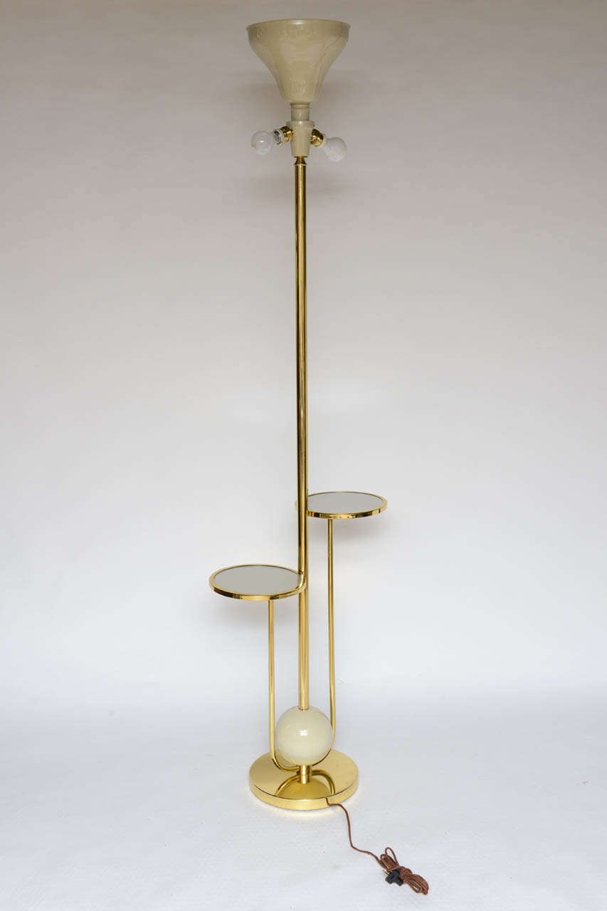 Two side bulbs and an up light (total of three lights) on polished brass tall floor lamp. Enamel and glass floating disc trays.

Shade not included.
 