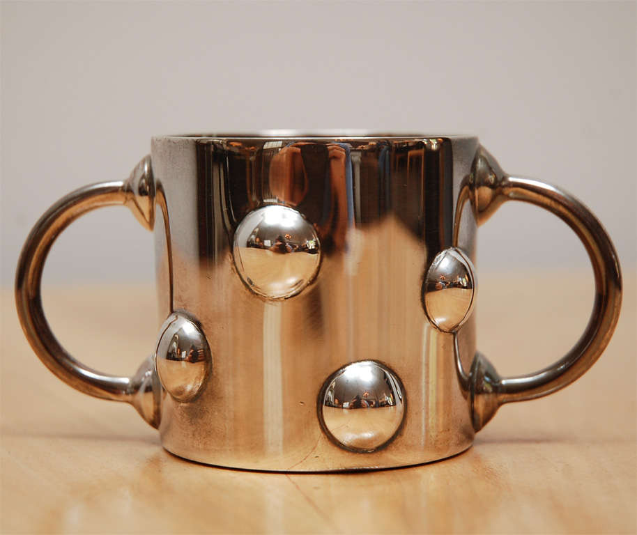 A silver plated child's cup, stamped on base:  (c) Swid Powell, Ettore Sottsass, Made in Argentina.<br />
<br />
Designed by Ettore Sottsass for Swid Powell.