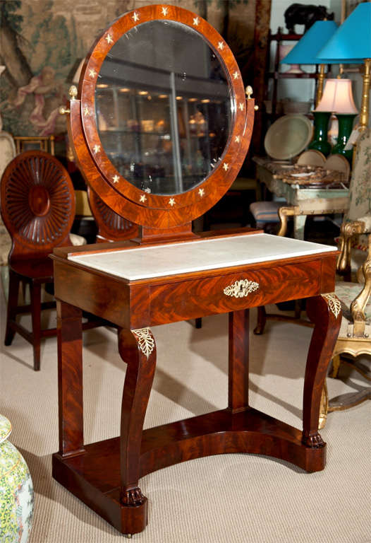 A French Charles X mahogany dressing table with original marble top and bronze decoration.  Pine cone finials perhaps later.