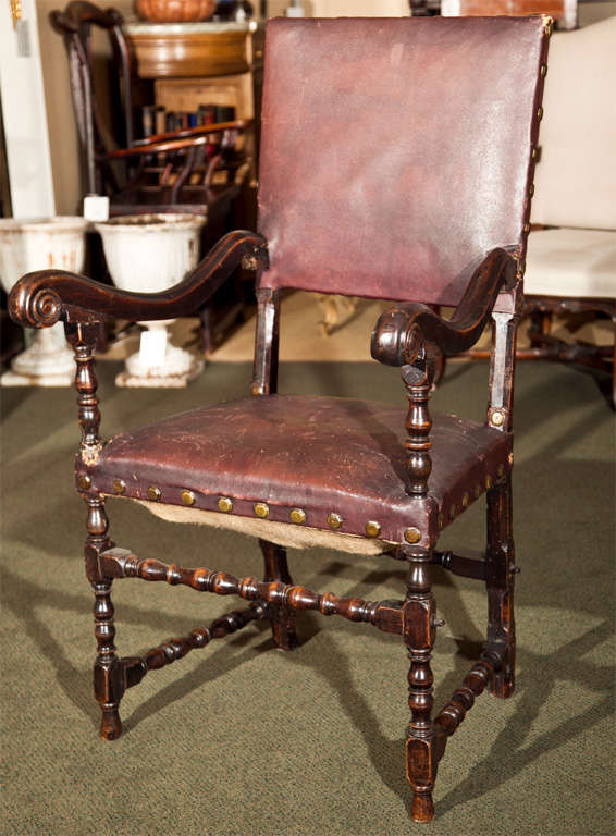 A 17th century Continental walnut armchair with turned legs and stretchers upholstered in brown leather.  Possibly Spanish.