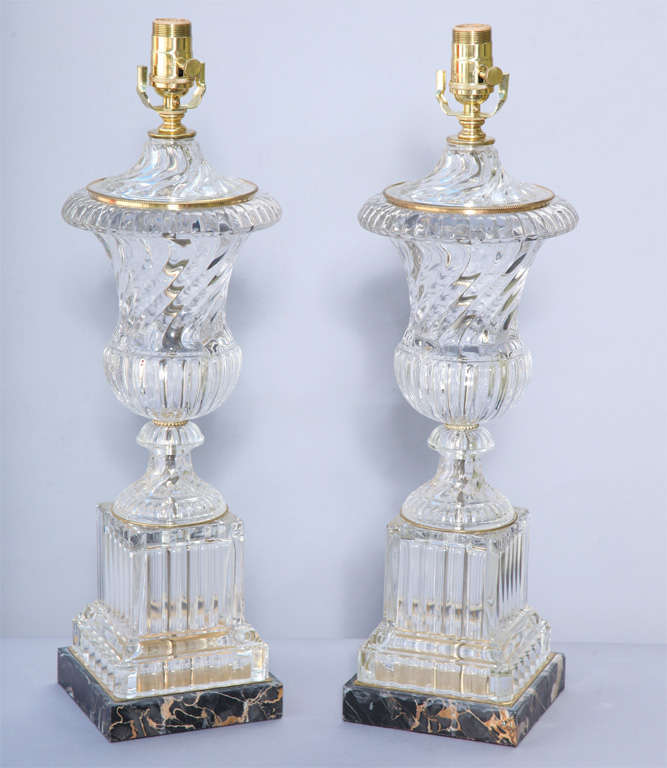Pair of urn shaped glass lamps, in Baccarat style, of fluted glass, on square black veined marble base.  
