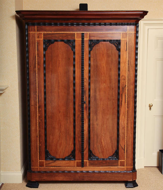 With ebony ripple cut molding and geometric banding throughout; each with two doors opening to a fitted interior including long drawers; one drilled to enclose a television.  Wonderful color and patina.