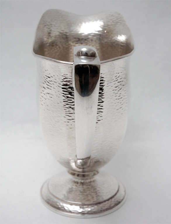 An elegant hammered silver plate pitcher by W.M. Mounts. Stamped on the bottom 
