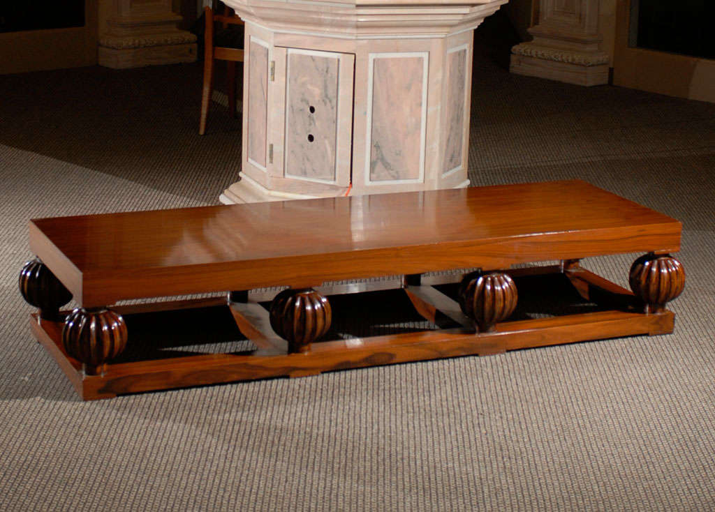 Coffee table of rosewood made in the Art Deco style with a platform base and decorative fluted balls.  