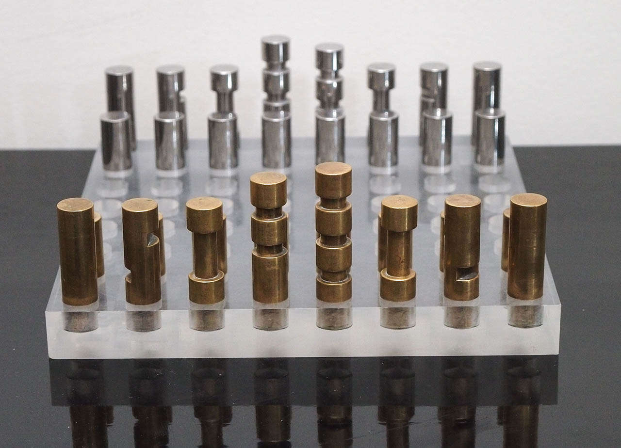 Handsome chess set with acrylic playing board; the playing pieces in machined bronze and nickel