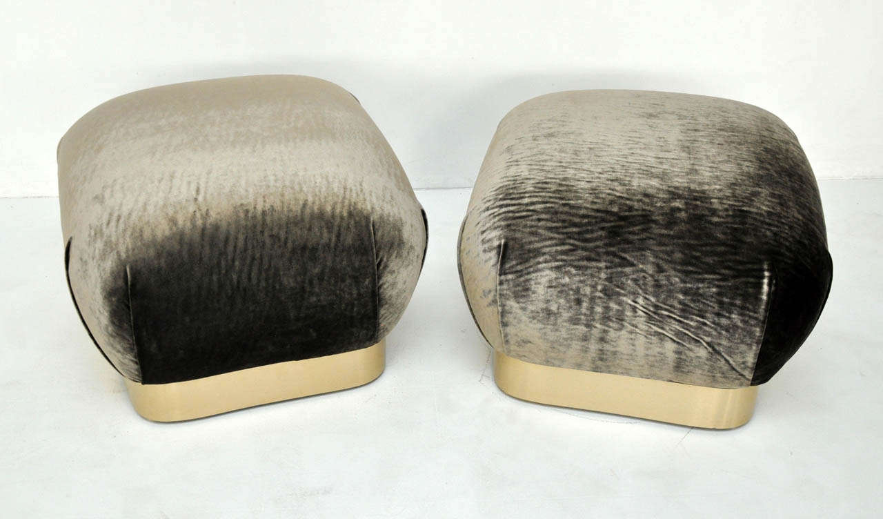 Large pouf ottomans in the manner of Karl Springer.  Newly upholstered over brass bases.
