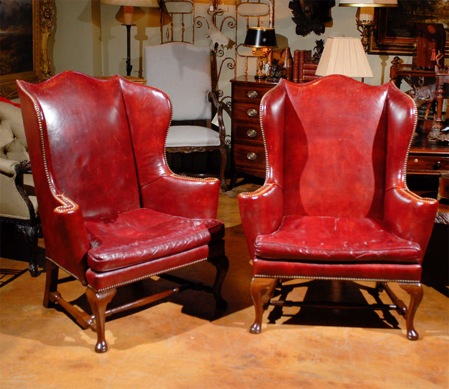 Pair of Colonial Williamsburg Kittinger red leather wing chairs, circa 1960.  Marked on bottom.<br />
<br />
To see more items from Foxglove Antiques, please visit our website: www.foxgloveantiques.com