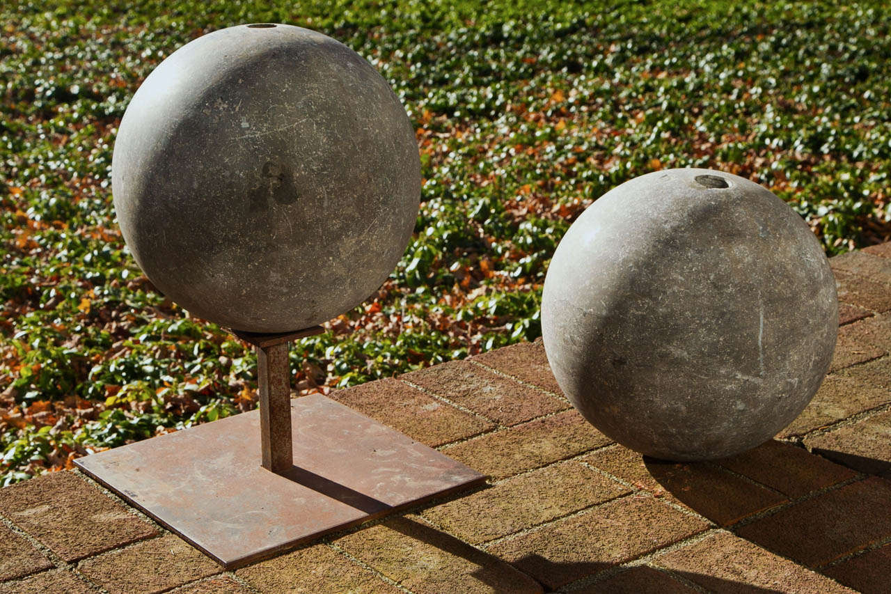 A pair of carved gray marble spheres.