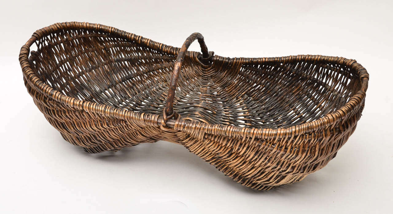 Un panier en osier de vendangeur français du début du siècle avec une poignée en bois de bruyère.
