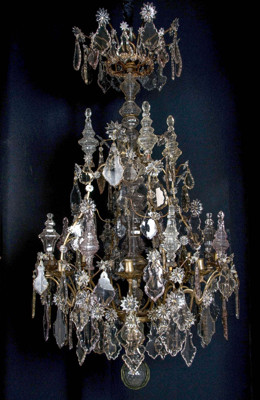 A very important French Louis XV period bronze and cut glass eight light chandelier. Mid 18th century. An open cage frame issuing sixteen S-scrolled branches, eight with floral shaped drip-pans and candleholders which are made of two
moulded