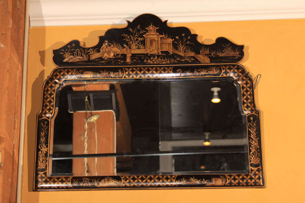 A good turn of the century English black lacquer chinoiserie overmantle mirror with lovely shaped top and original bevelled glass