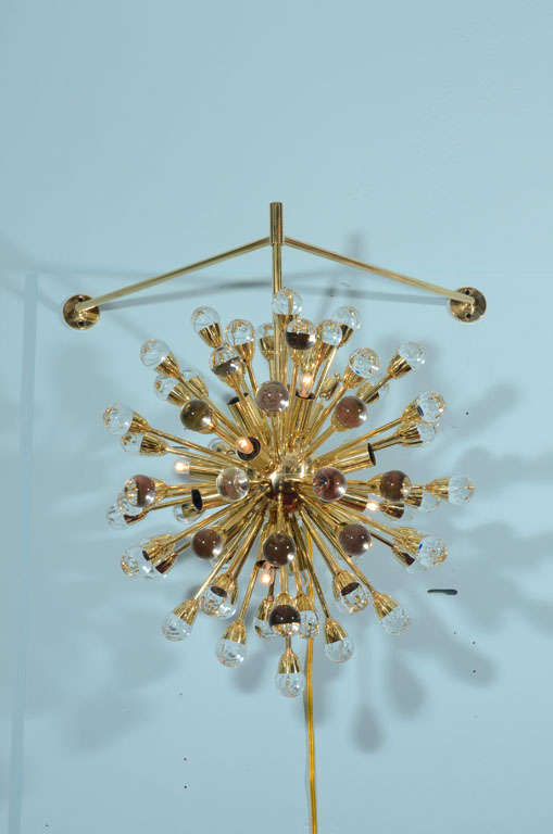 This incredible light has three arm supports that allow it to suspend freely. 65 arms with crystal globe shapes, and 16 candelabra sockets.  Handmade in Italy in polished brass.  Great scale and a very elegant presence.