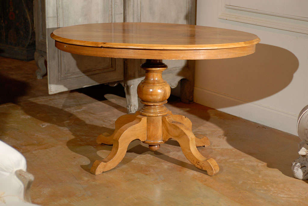 A French oval walnut Louis-Philippe centre pedestal table from the 19th century. This French center table features the typical traits of Louis-Philippe tables. The walnut top with its rich grain is oval. The lines, inspired by the Rococo Revival