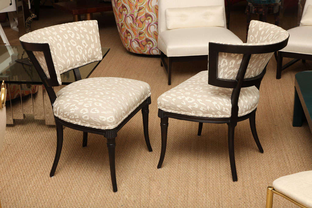 These elegant Grosfeld House Hollywood Regency side or slipper chairs have an unusual beaded wood detail, that is pierced carvings to the apron of the front of the chairs. The saber splayed legs add a sheer elegance. They have been re-upholstered in