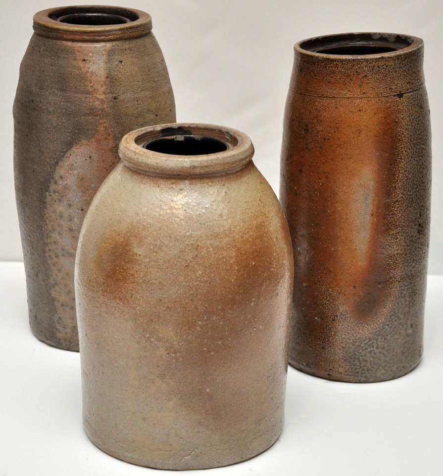 Set of Three 3 American stoneware jars with a salt glaze finish and beautiful gray and amber coloring. The jars were originally used in the preservation of fruit chutney and had wax seal tops. 

Dimensions: 
Jar 1: 9.75