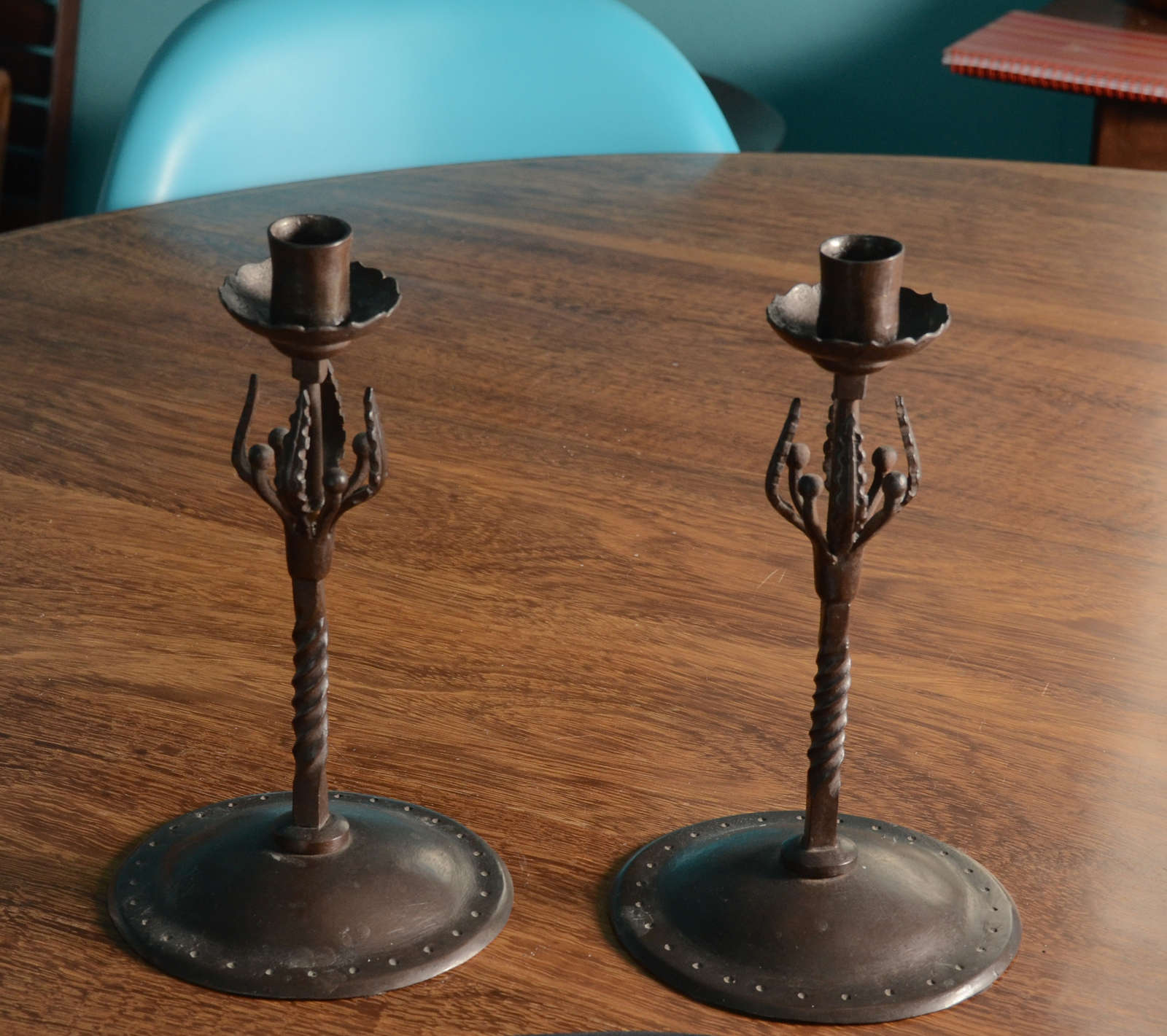 Pair of Wrought Iron Candleticks with domed base, twisted shaft rising to Leaf & Pod ornament.  Candle Holder is rimmed with ogee forms.  Fine example of English Arts & Crafts designed by Edward Spencer for The Artificer's Guild, circa 1910.  Great