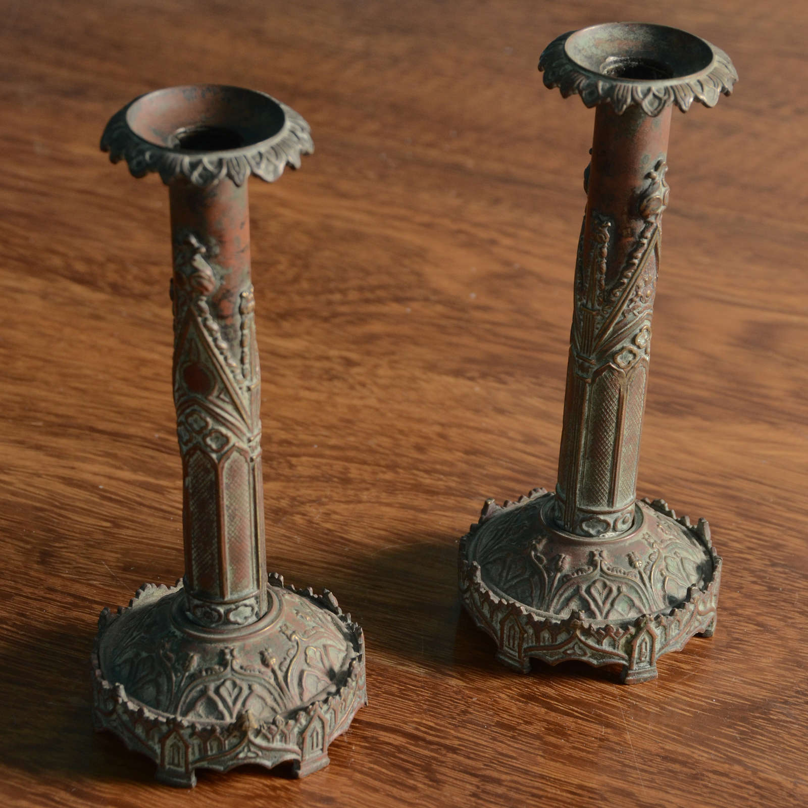 Candlesticks with stamped Gothic architectural ornament: crockets, tracery, trefoils.  Candle holders are removable.  Similar to 