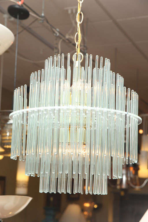 REDUCED FROM $1,500...Sporting hundreds of blown glass rods, this three-tiered chandelier is inspired and totally gorgeous. With a central body of eight brass socket fittings and a single Lucite shelf that holds all the crystals, it is a Minimalist
