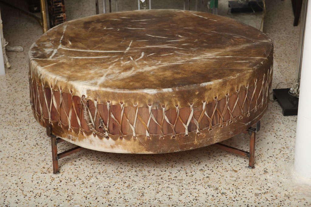 Set into a custom copper frame, this over-scaled rawhide and wood drum serves as a dramatic, rustic coffee table.
