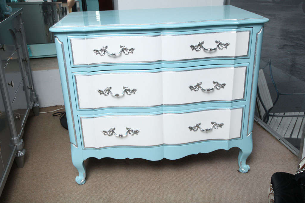 A pair of very nice, hip drawers. Lacquered baby blue and white with silver leaves accents. Chrome handles finish the pieces off and blend flawlessly with the silver accents.