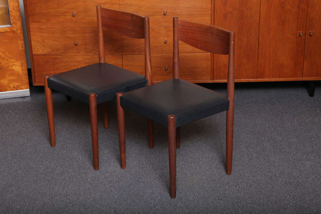 A set of four smart teak dining chairs designed by Poul Volther and produced by Frem Rojle in Denmark. Beautifully crafted with a Shaker simplicity, the richness of the teak readily apparent. Original black leatherette seat covers with small signs