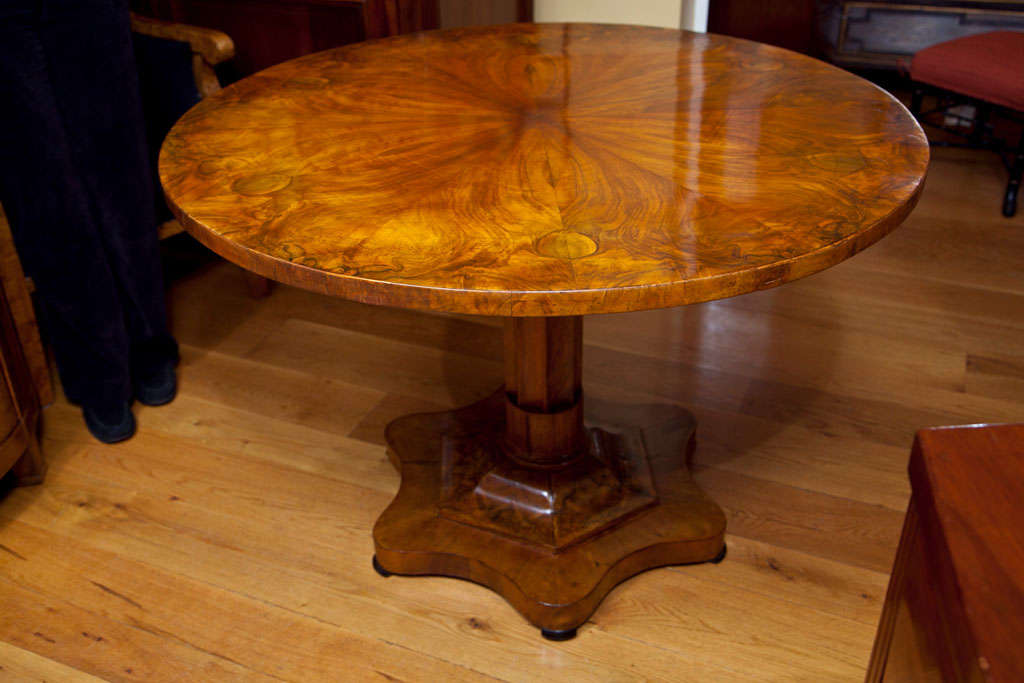 Fine and early Biedermeier circular tilt-top table with a beautiful sunburst veneered plateau in a highly figured walnut root, finishing on a single stepped baluster base on ruffled plinth and ebonized trim.
