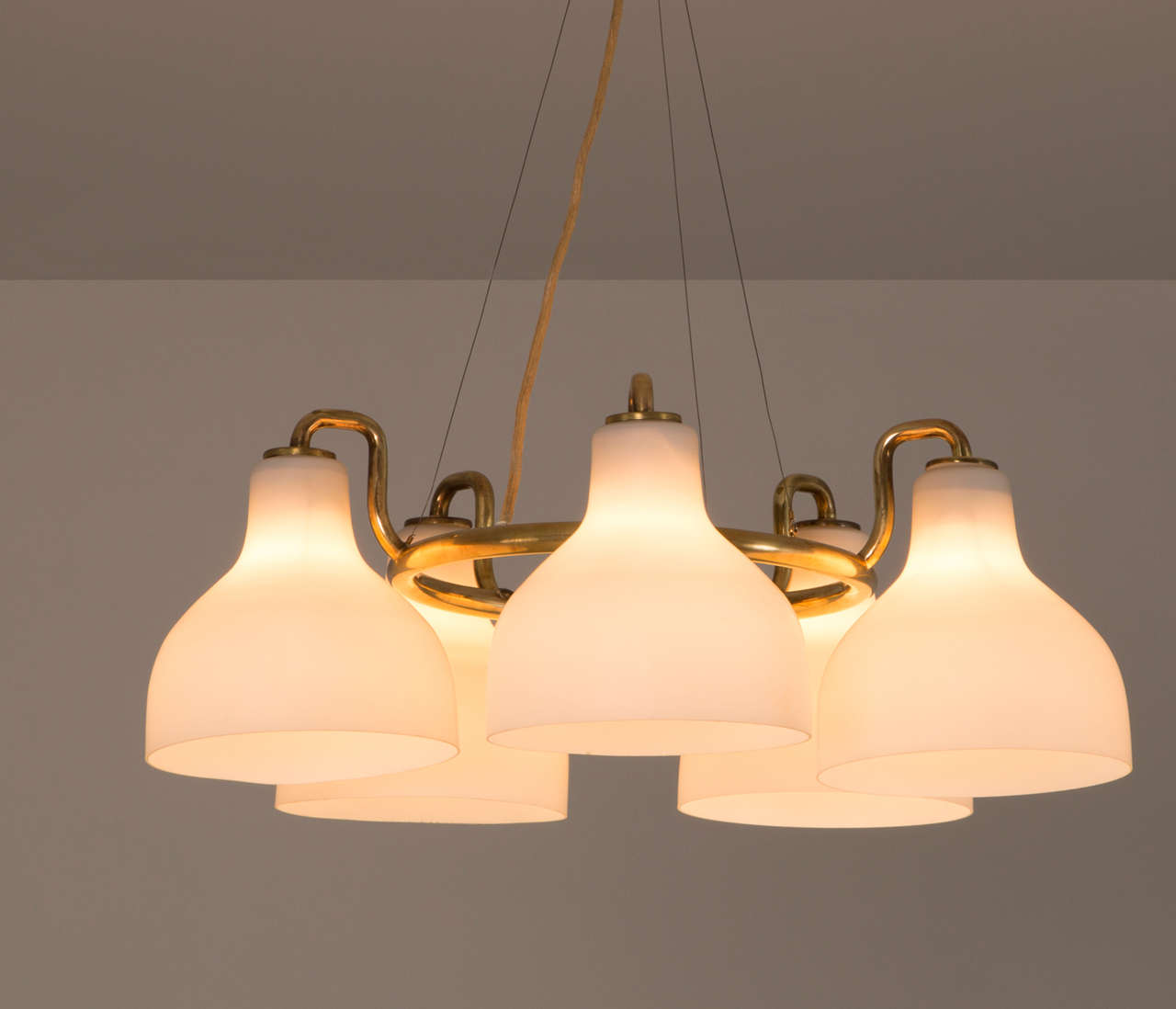 Chandelier, in metal and opaline glass, by Vilhelm Lauritzen for Louis Poulsen, Denmark 1950s.

Single chandelier by Vilhelm Lauritzen. The brass finished ring contains five opaline milk glass shades with a matte finish to create an excellent