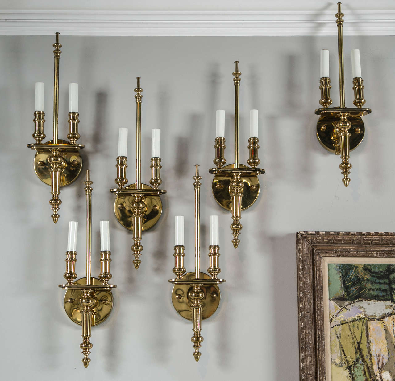Pair of Solid brass sconces. Each scone has two candles and an acorn finial detail on bottom.
