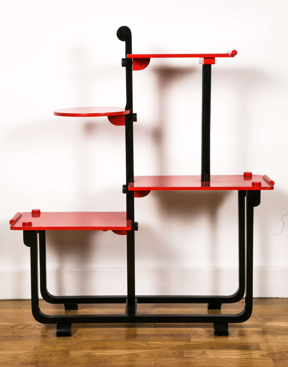 Very elegant modernist style Art Deco shelves by André Groult (1884-1966). Wooden structure topped with four shelves assembled by large visible wood screws (see photo). Black lacquered structure and red lacquered shelves.