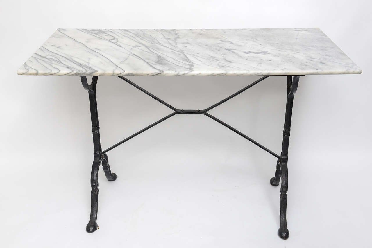 Charming black iron and marble-top rectangular bistro table.
