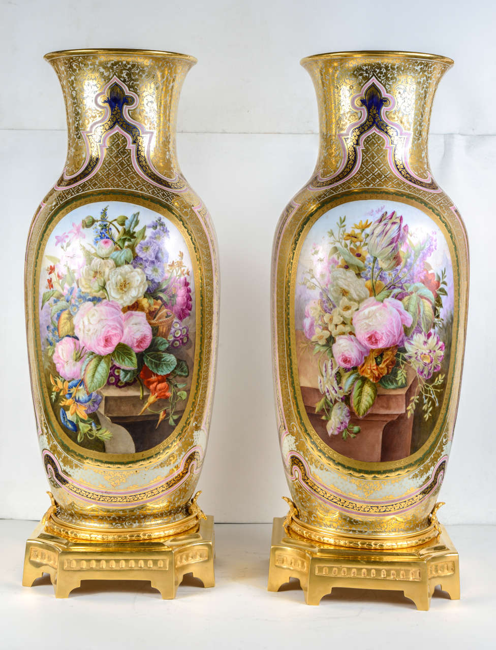Pair of vases resting on a gilded bronze base, porcelain of Bayeux finally decorated on two faces with colored flowers.