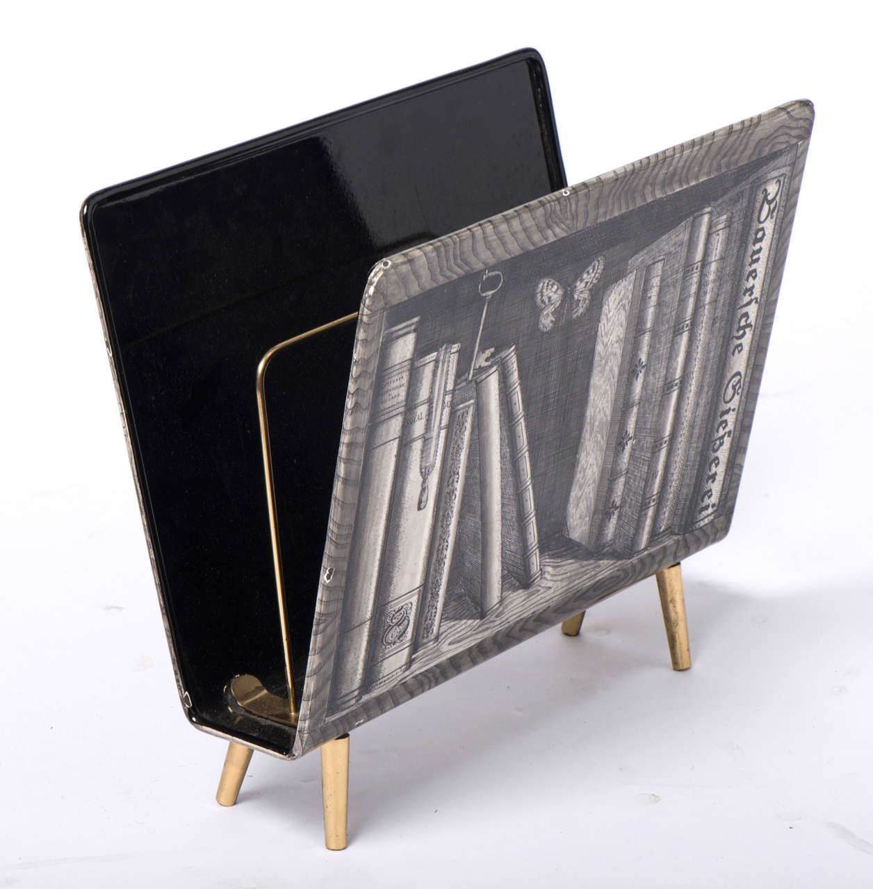 An Atelier Fornasetti “Libri” magazine rack.
Lithographically printed metal on brass feet.
Italy, circa 1988-1989.
Label to base.
Measures: 39cms H x 42.5cms W x 22cms D.