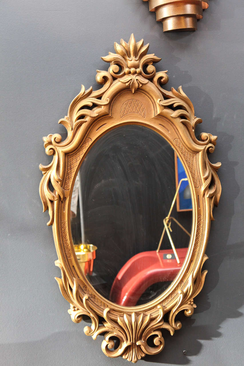 Oval Regency style mirror framed with gold gilt finish.