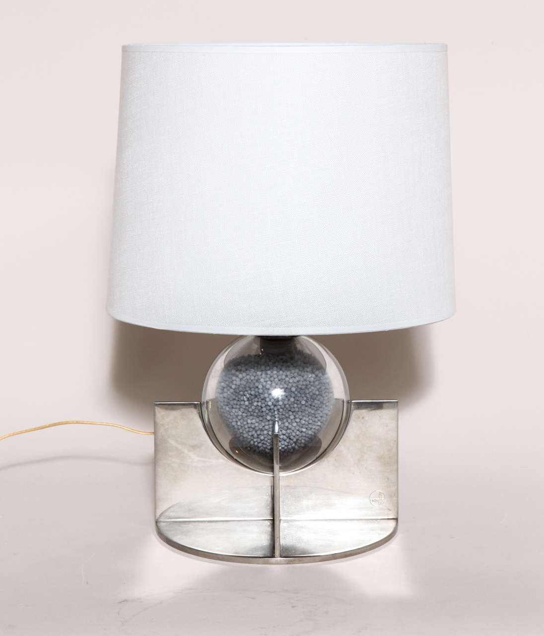 A table lamp with a clear glass sphere filled with small lead pellets on a nickelled brass cruciform base with a silk shade.
With original French electrical components, but newly rewired to American standard and with a dimmer switch.
Good working