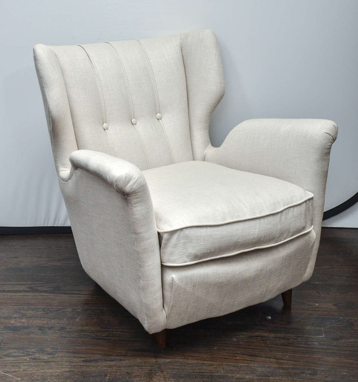In the style of Gio Ponti Mid-Century pair of modern club chairs with notched out arms and deep seat cushion upholstered in linen.