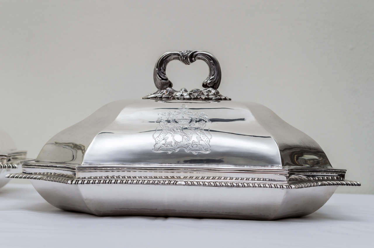 Pair of early 19th century Georgian sterling silver covered entree dishes. Identical forms and design with elegant shaped octagonal sides. Each cover has a solid ornate detachable handle and a beautifully engraved armorial coat of arms of leopards