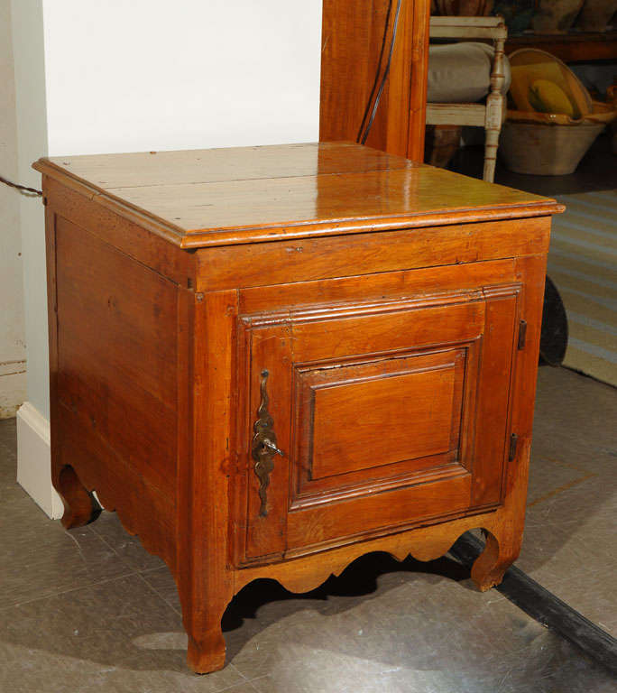 Provincial walnut cellarette (cabinet for storage of wine bottles) with a hinged top as well as a door (with lock). Pegged construction, hand-carved details in the style of Louis XV, but later than the period, circa 1800. Would be a great chairside