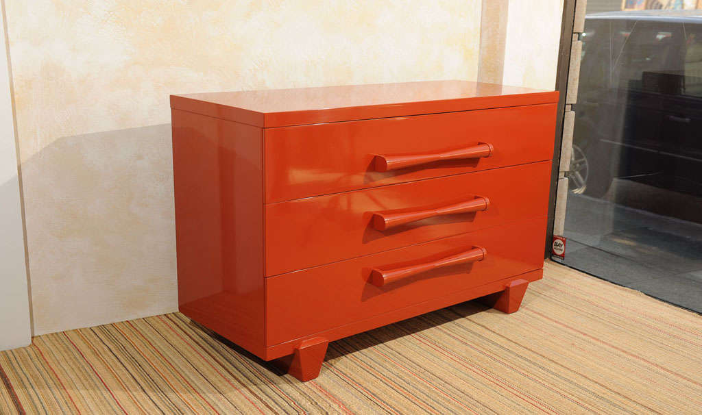 A freshly lacquered orange three drawer low chest