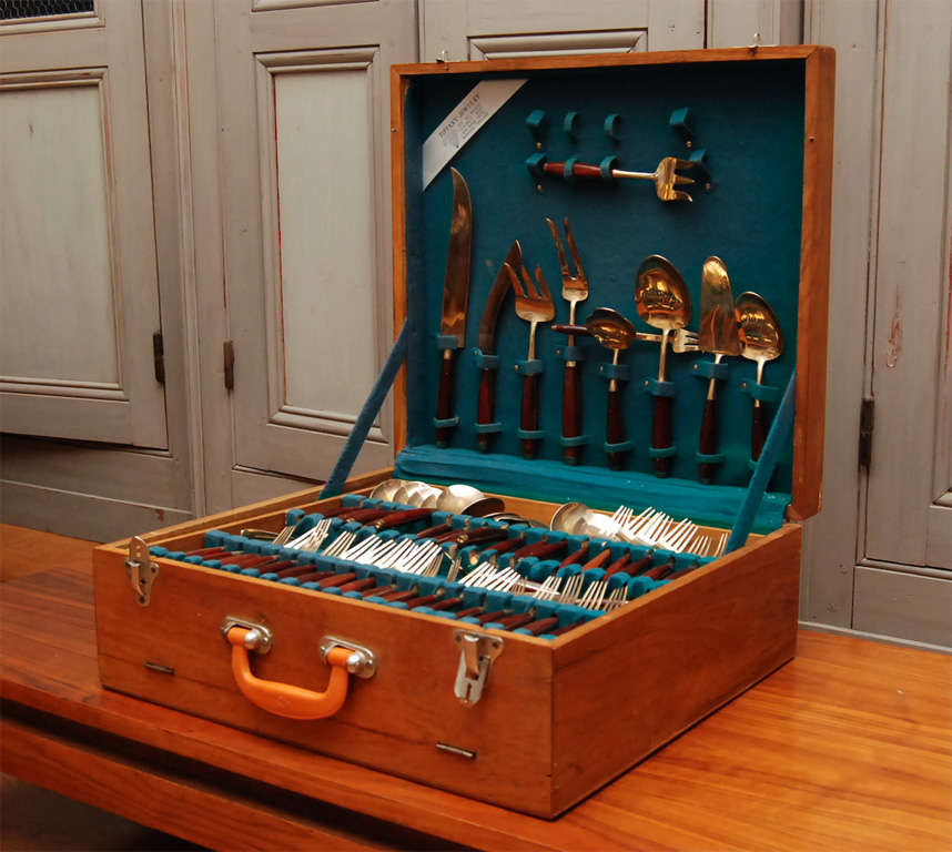 an incredible, 144 piece flatware set, service for 12 from Thailand, with 24 extra forks and knives and 12 serving pieces.beautifully, gold plated on rosewood handles, in original, three tiered trunk and label from: <br />
Tiffany Jewelry,<br