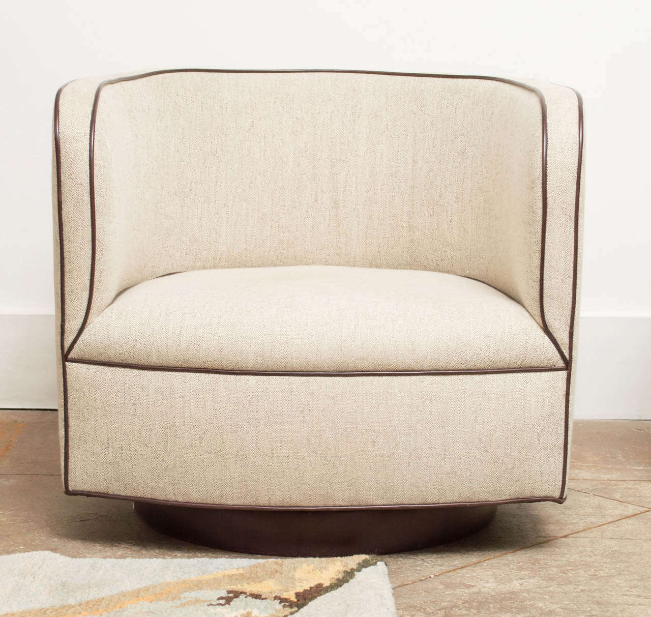 A Barrel shaped Swivel-Rocker Chair by Milo Baughman for
Thayer Coggin. Features a low seat and walnut base. Upholstery is heathered beige linen, with contrasting brown piping.