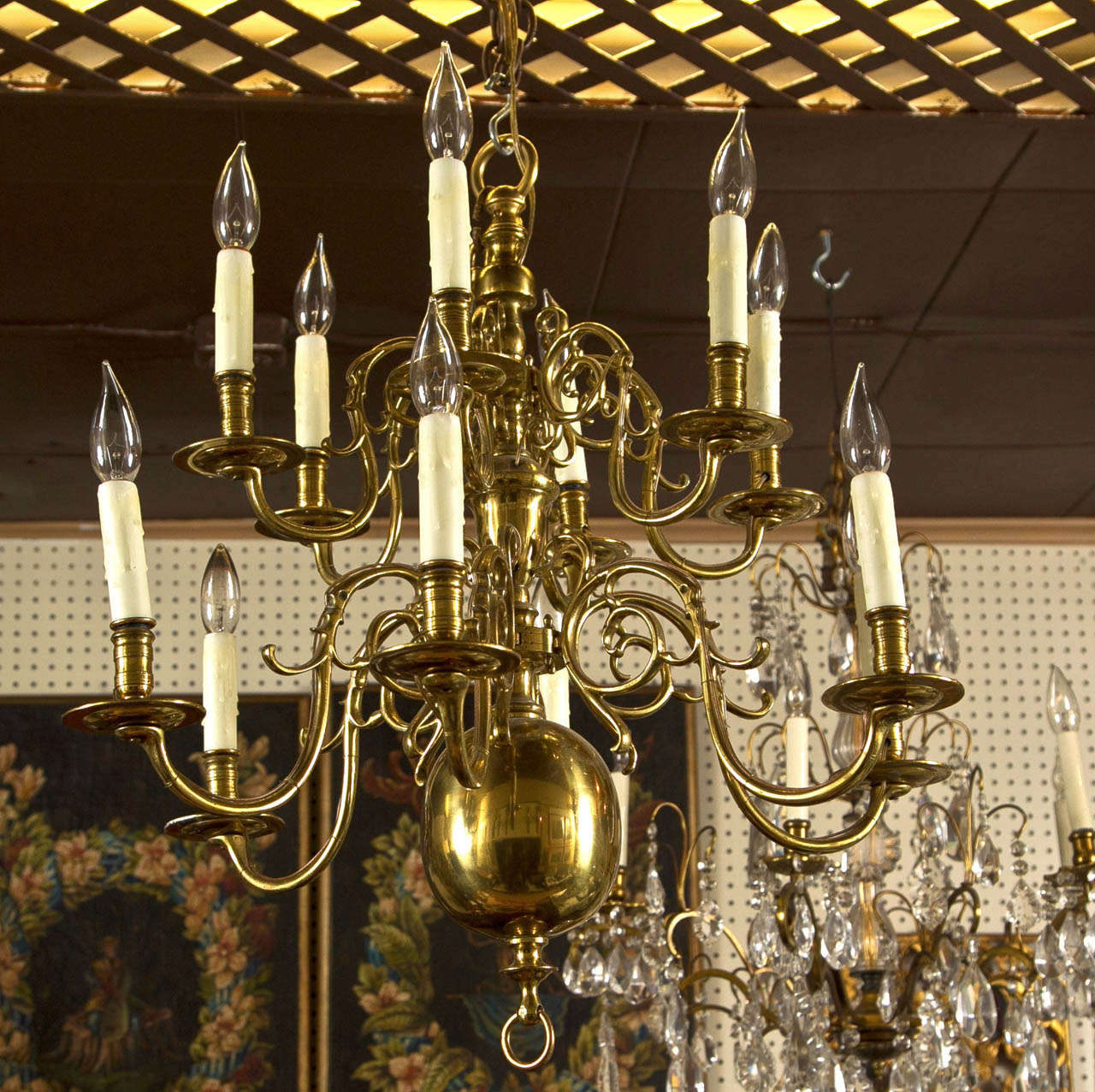 a  2 tier  12  light,   brass chandelier in the Dutch colonial  style.  scrolling arms emanate from central fittings. ring lower and  upper finial.
wired.