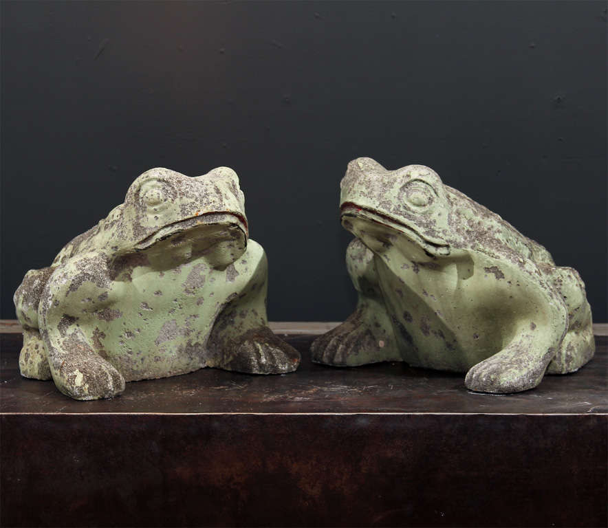 Vintage matched pair of cast concrete frogs with traces of old green paint and great patina.  Exaggerated eyes and feet make these almost cartoon-like in playful appeal.