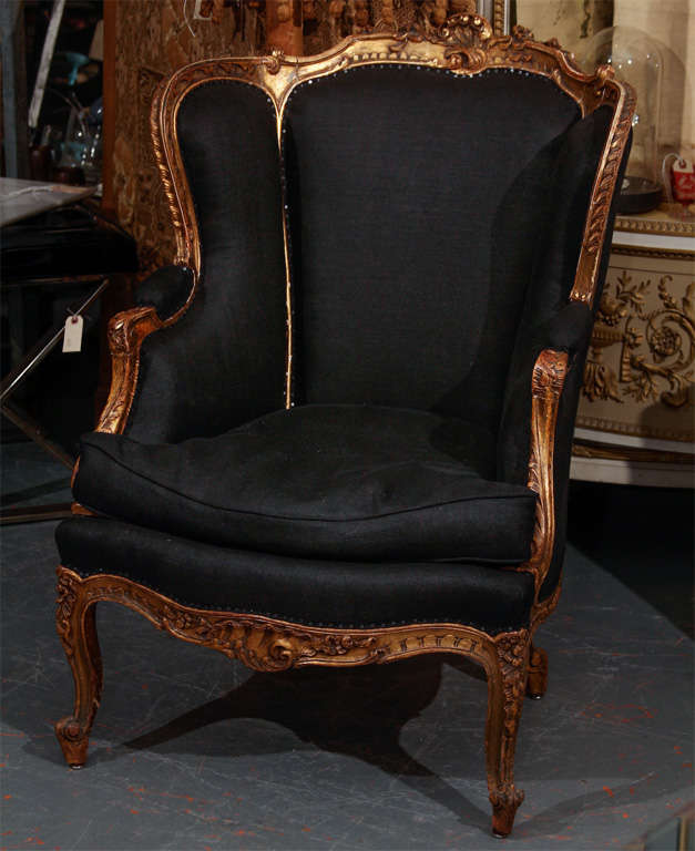 very comfortable carved wood, gilded french chair in black linen.  down cushion